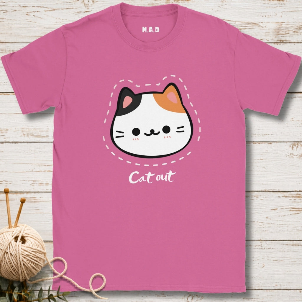 Pink t-shirt with a cat graphic and 'Cat out' text on a wooden surface.