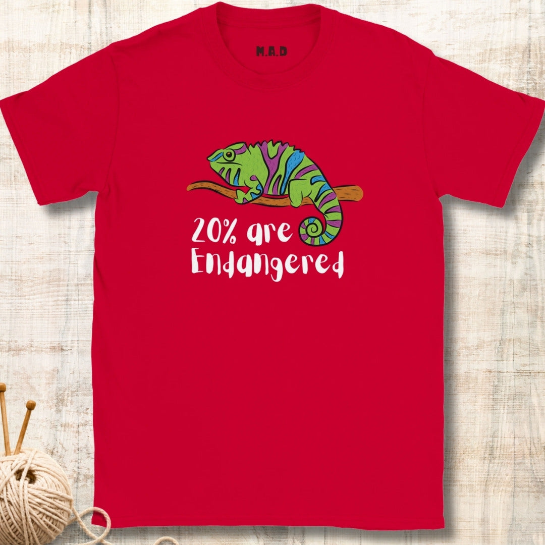 Red t-shirt with a colorful chameleon and text '20% are Endangered' on a wooden surface.