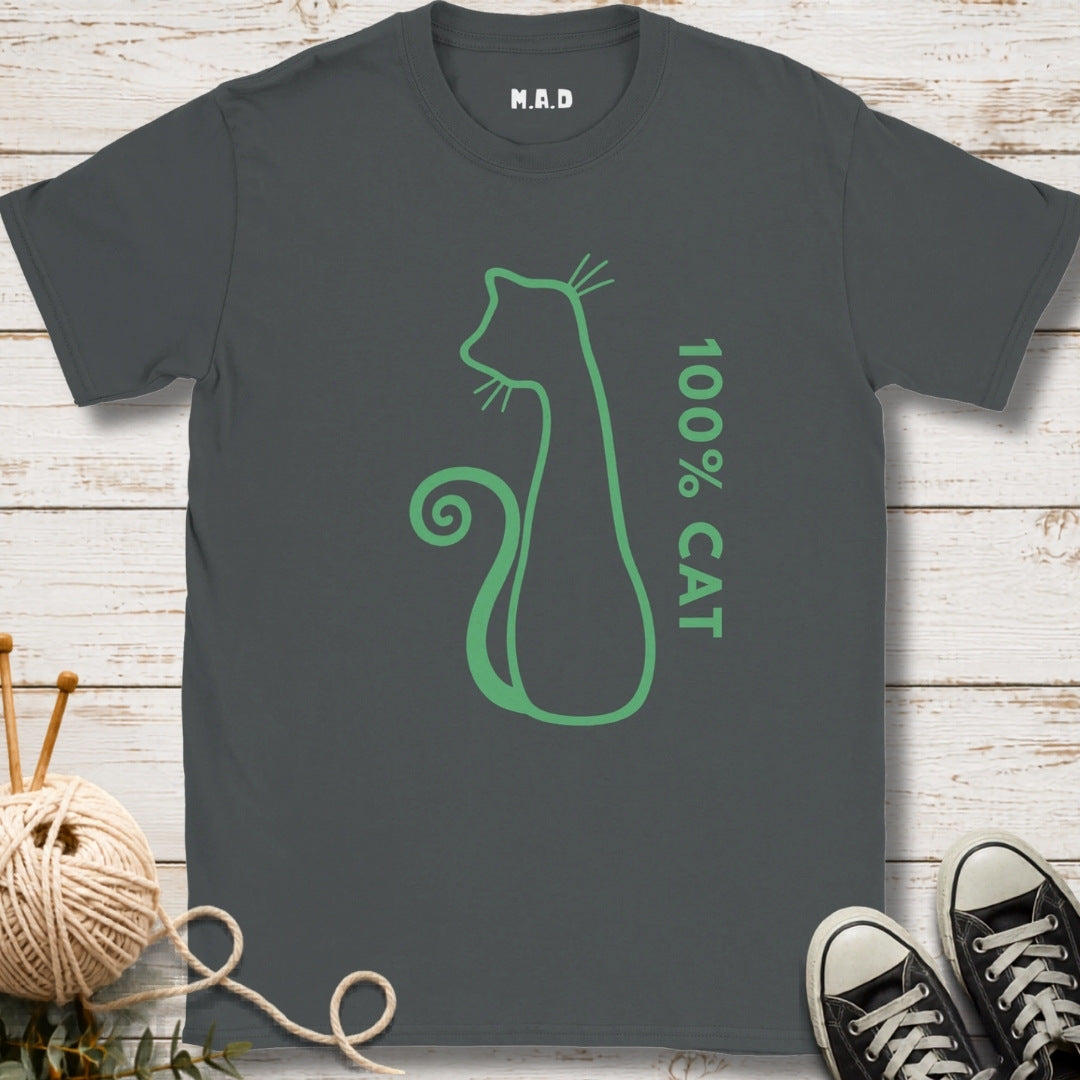 A dark gray crewneck t-shirt with a green cat silhouette outline and the text '100% CAT' printed on the front. The shirt is displayed in a flat-lay arrangement on a white wood background, styled with a ball of yarn, knitting needles, and black sneakers.