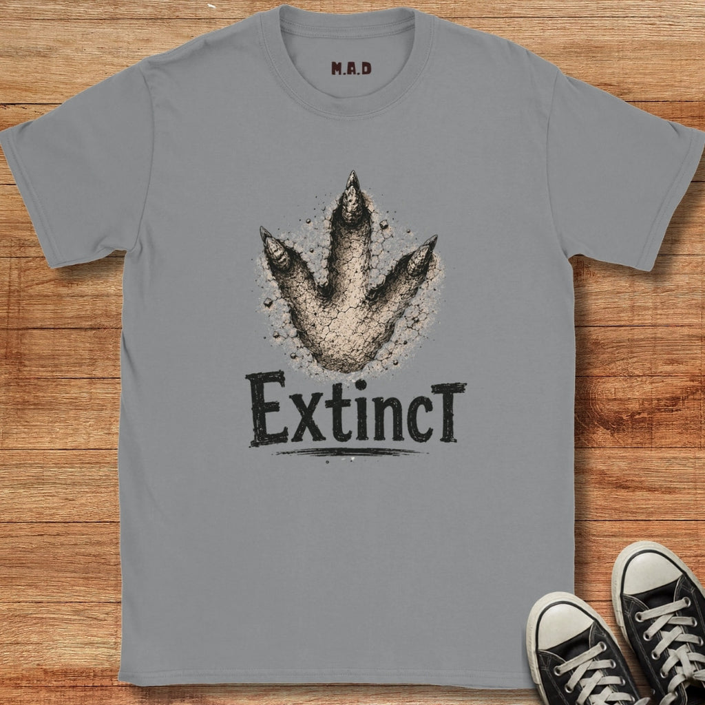 Gray t-shirt with dinosaur footprint graphic and 'Extinct' text on a wooden surface