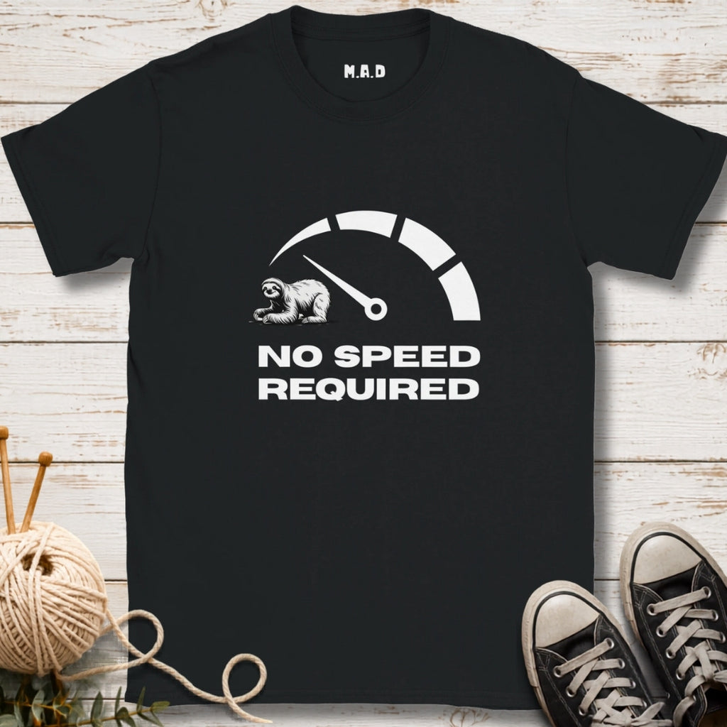Black t-shirt with 'No Speed Required' graphic on a wooden surface with sneakers and yarn.