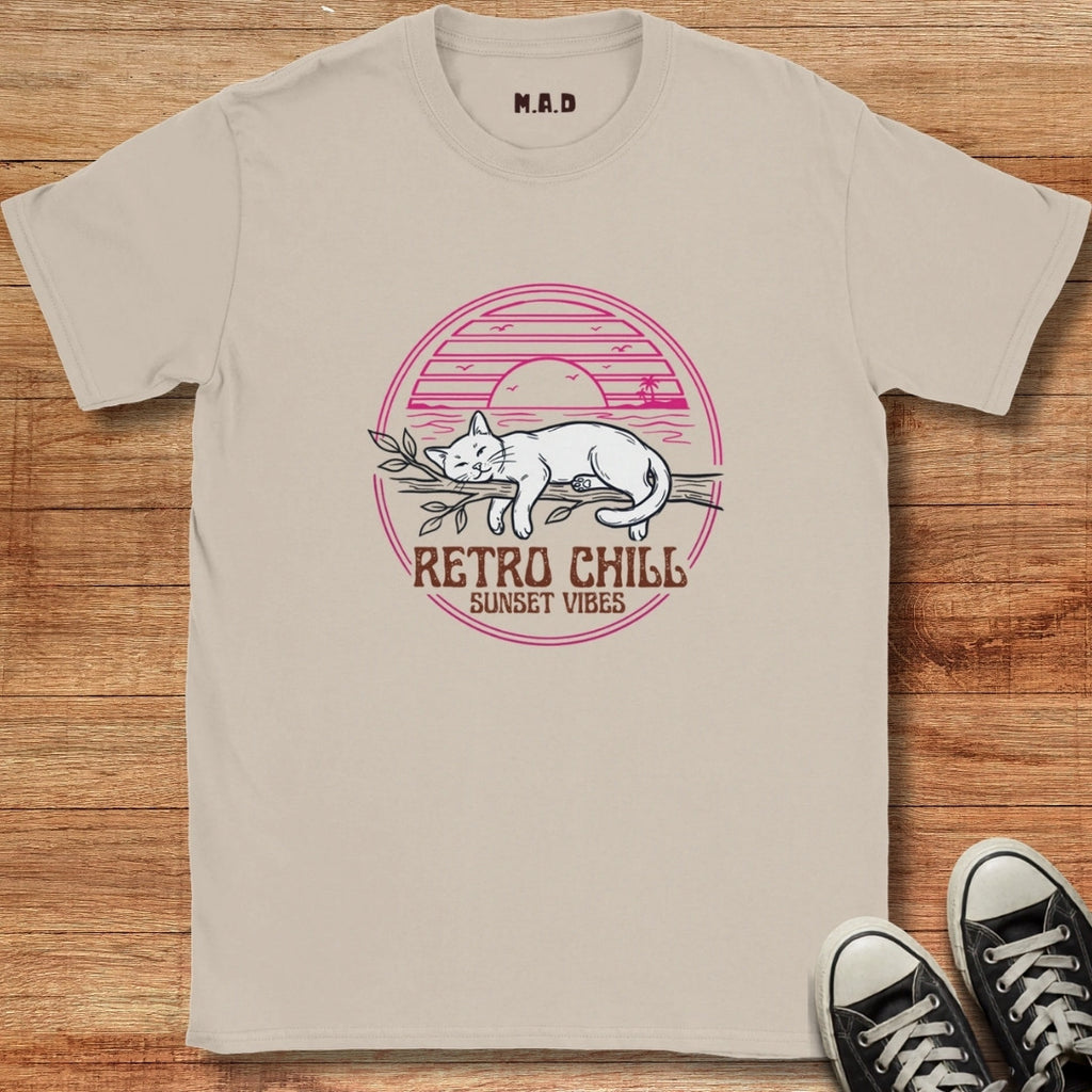 Beige t-shirt with a cat graphic and 'Retro Chill Sunset Vibes' text on a wooden surface.