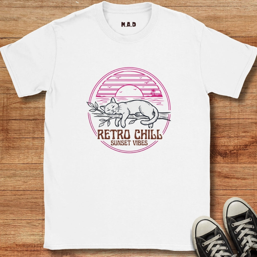 White t-shirt with 'Retro Chill Sunset Vibes' design on a wooden surface with black sneakers.